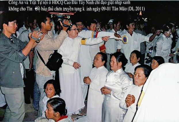 Các tín hữu Cao Đài chơn truyền đang tiến hành tụng kinh cúng lễ bỉ an ninh bao vây và trấn áp (năm 2011)